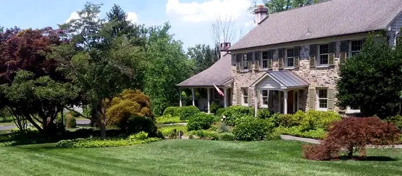 green healthy grass in front of stone home